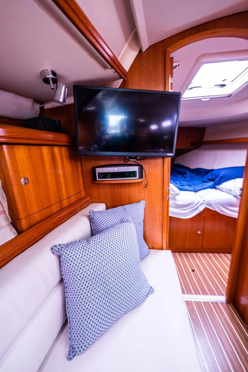 Slide: The Image of Interior of 2005 Hunter 38 yacht with TV, cushions, and cozy cabin. - 55