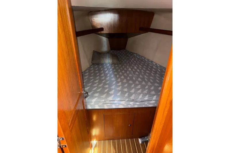Slide: The Image of Cozy cabin interior of 2005 Hunter 38 sailboat with wooden finish and patterned bedding. - 56
