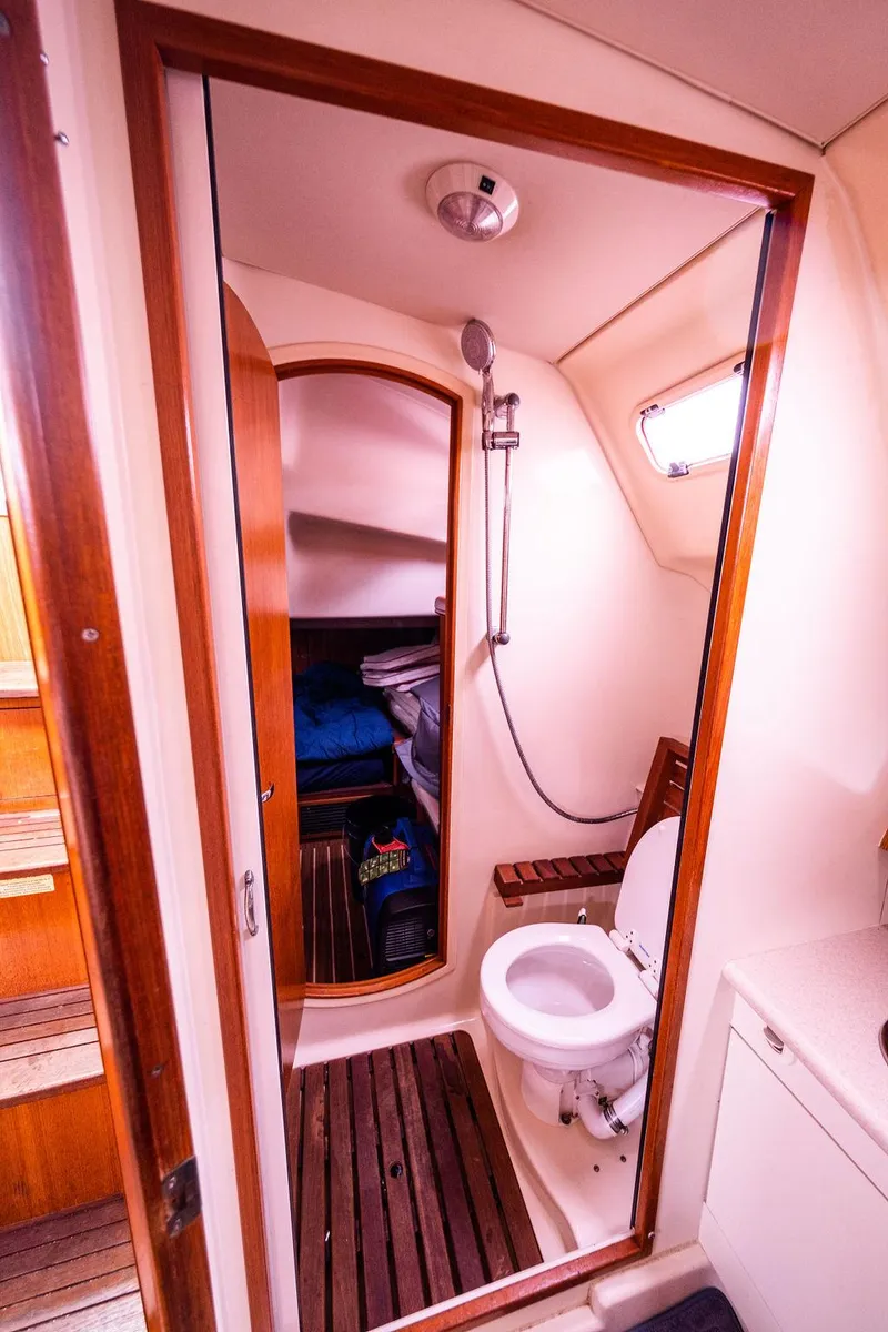 Slide: The Image of 2005 Hunter 38 yacht bathroom with shower, wooden accents, and compact design. - 61
