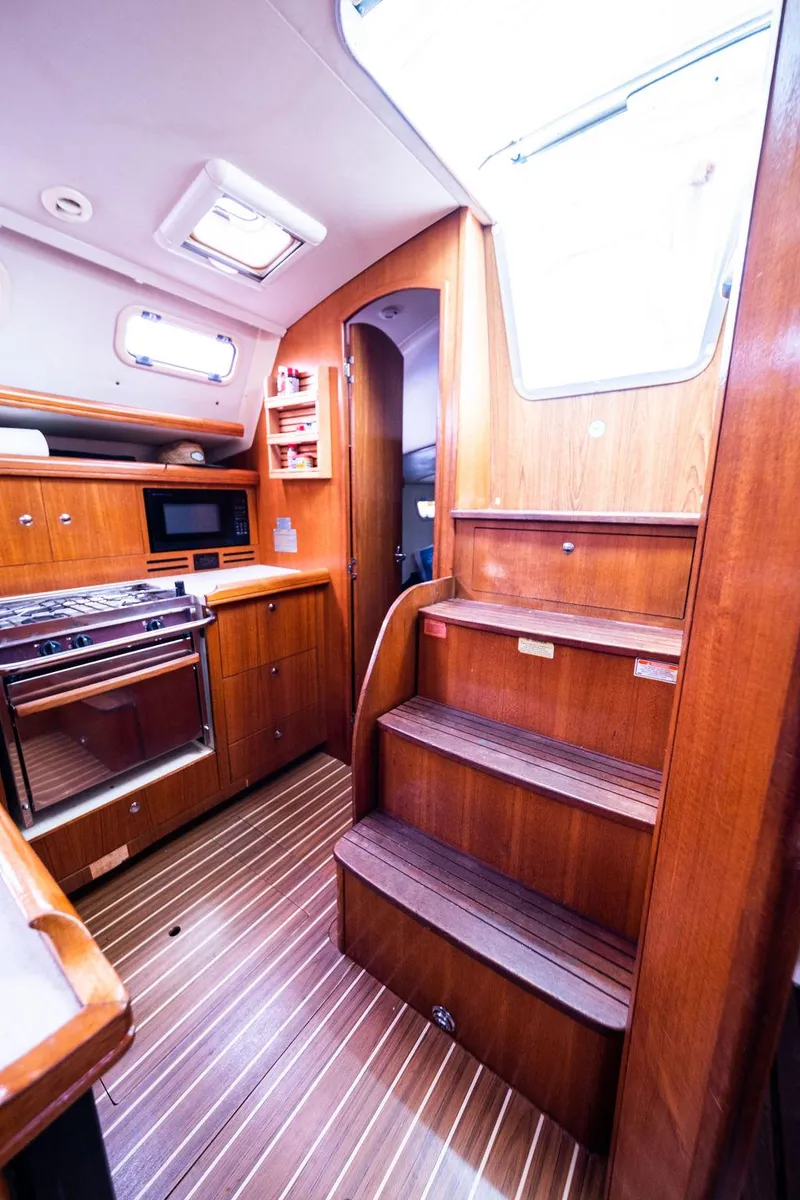 Slide: The Image of Interior of 2005 Hunter 38 sailboat with wooden cabinetry and stairs. - 64