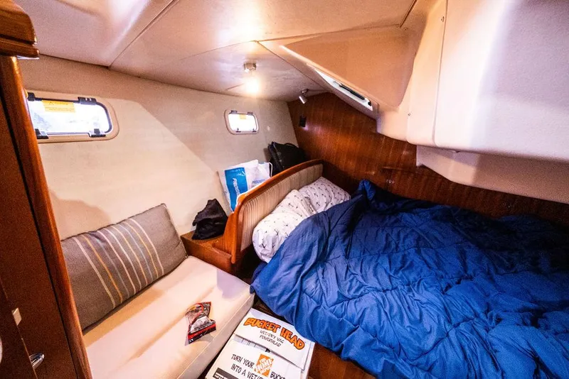 Slide: The Image of Cozy cabin interior of 2005 Hunter 38 sailboat with bed, sofa, and portholes. - 65