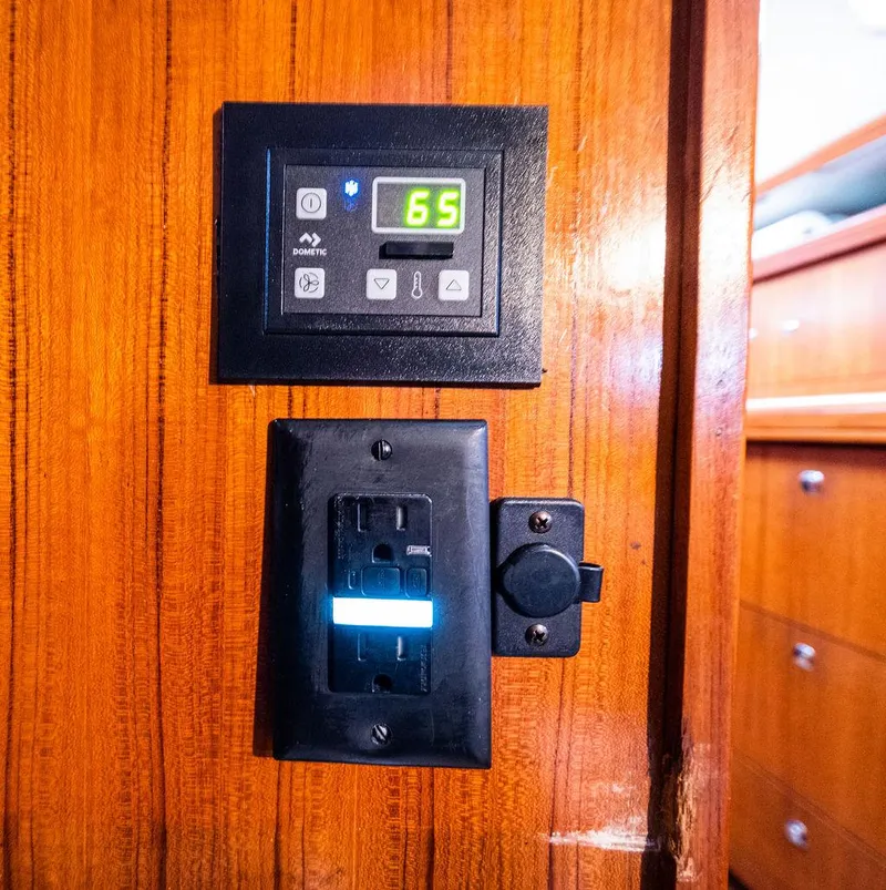 Slide: The Image of Control panel and outlet on 2005 Hunter 38 yacht's wooden interior wall. - 74