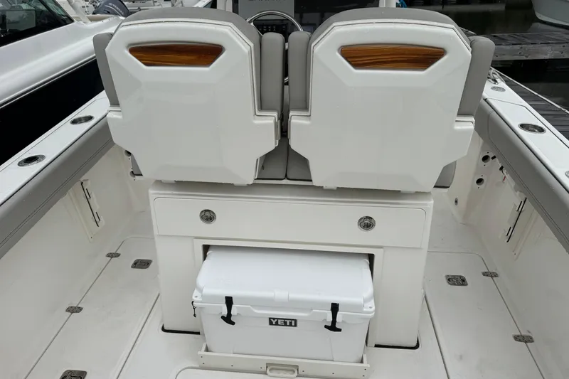 Slide: The Image of 2024 Pursuit S 248 Sport boat interior with dual seats and Yeti cooler. - 12