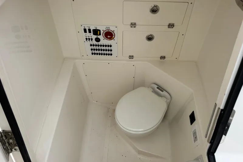 Slide: The Image of 2024 Pursuit S 248 Sport boat interior with toilet and control panel. - 14