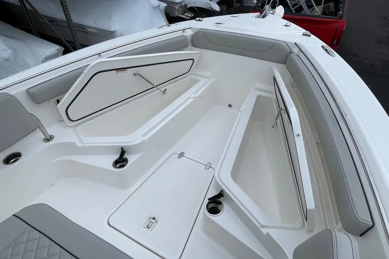 Slide: The Image of 2024 Pursuit S 248 Sport boat interior with open storage compartments and seating. - 16