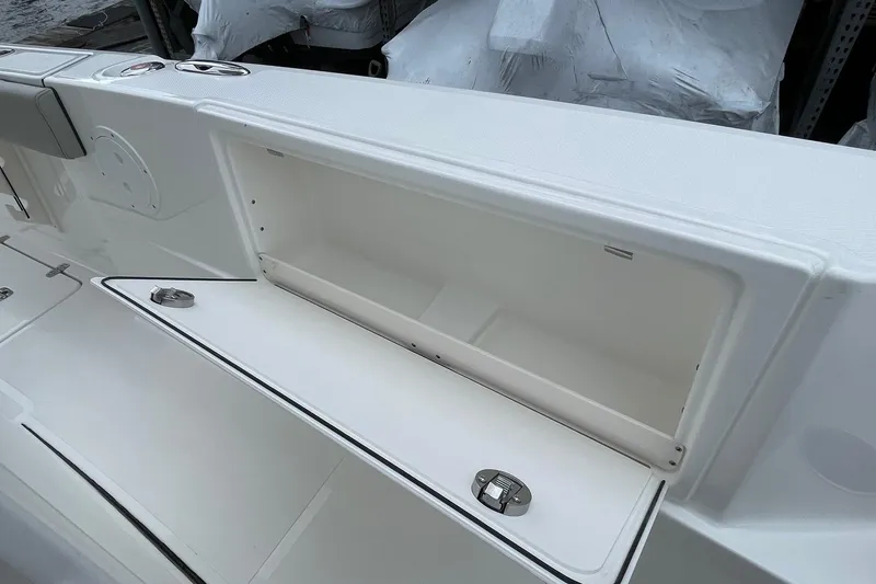 Slide: The Image of 2024 Pursuit S 248 Sport boat storage compartment, open and empty, showcasing interior space. - 23