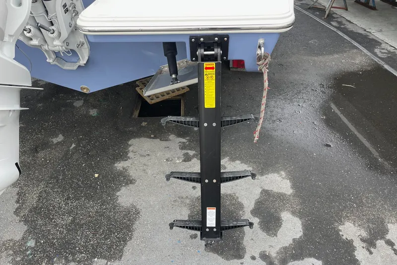 Slide: The Image of 2024 Pursuit S 248 Sport boat with a foldable ladder on wet pavement. - 26