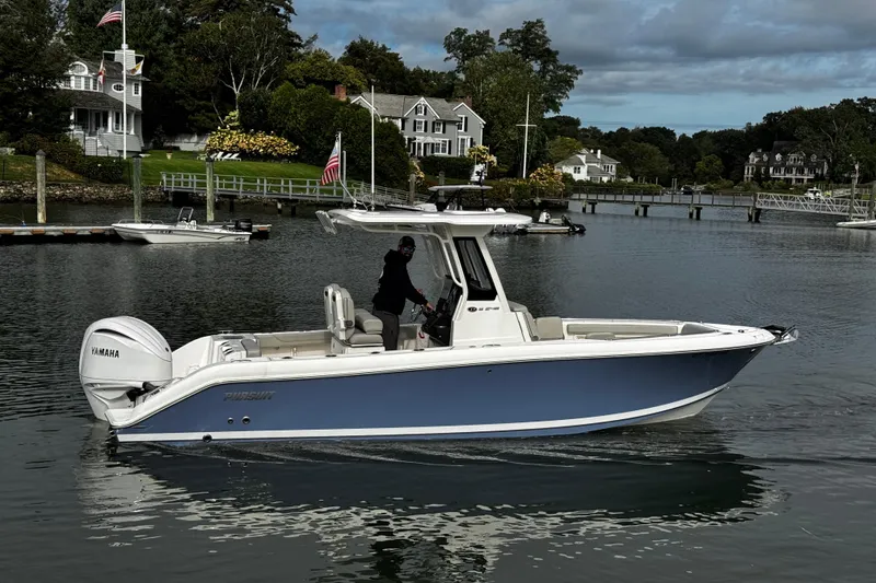 Slide: The Image of 2024 Pursuit S 248 Sport boat on calm water near residential docks. - 4