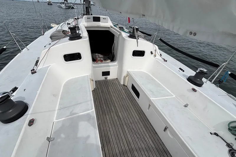 Slide: The Image of 2008 J Boats J/122 sailboat cockpit with teak flooring and winches, docked on calm water. - 22