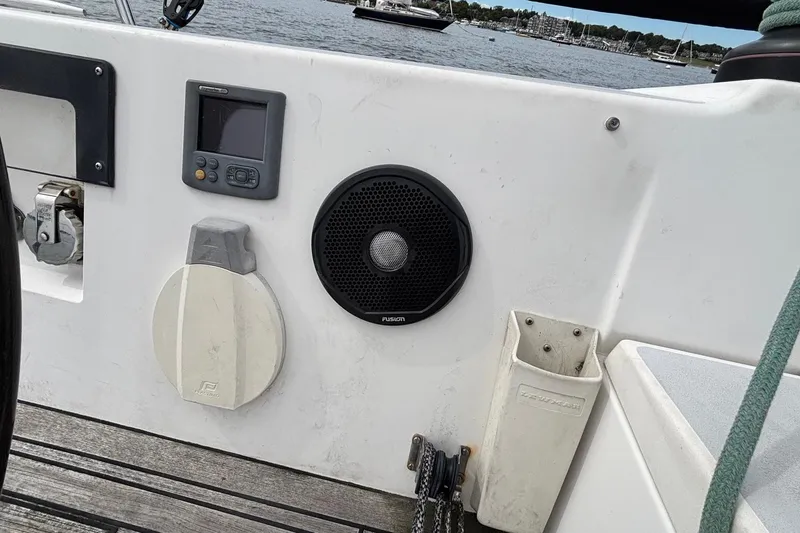 Slide: The Image of 2008 J Boats J/122 cockpit with navigation equipment and speaker, docked by the water. - 25
