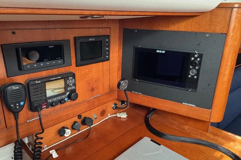 Slide: The Image of 2008 J Boats J/122 navigation equipment with B&G displays and Icom radio on wooden panel. - 32