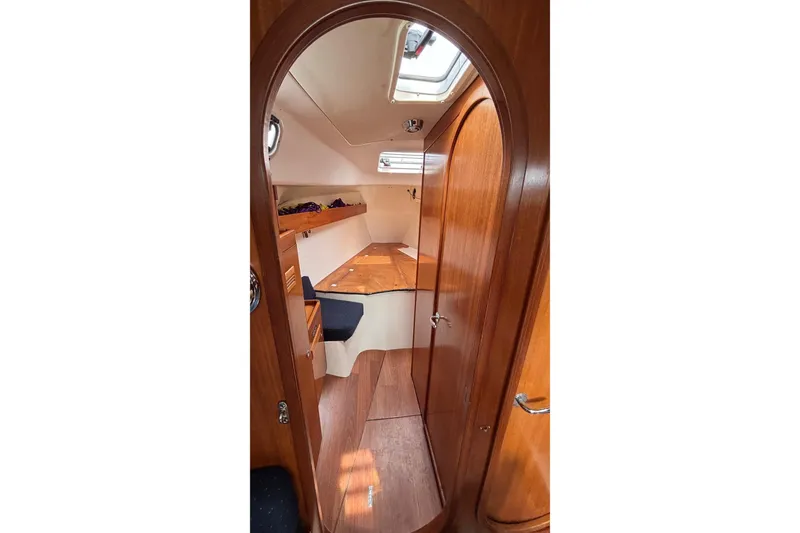 Slide: The Image of Interior of 2008 J Boats J/122 sailboat, featuring wooden cabinetry and cozy sleeping area. - 41