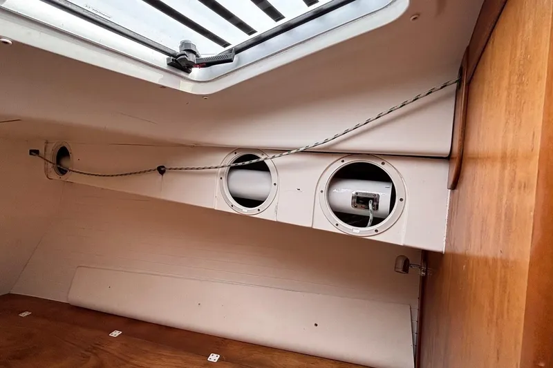 Slide: The Image of Interior view of 2008 J Boats J/122 sailboat cabin with portholes and wooden paneling. - 44