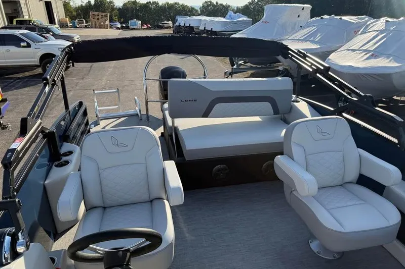Slide: The Image of 2026 Lowe SS 230 DV boat interior with plush seating and steering wheel. - 13