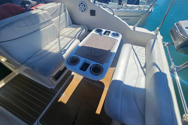 Slide: The Image of Interior seating area of 1999 Maxum 2400 SCR boat with table and cup holders. - 10