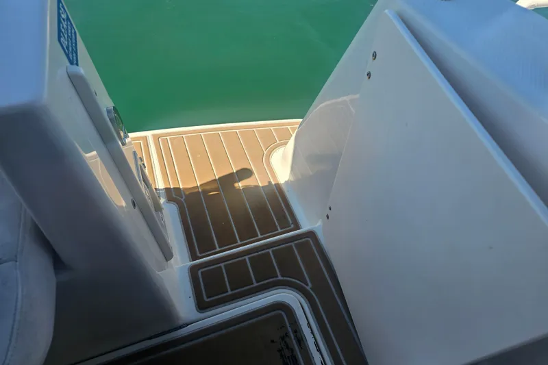 Slide: The Image of 1999 Maxum 2400 SCR boat deck with wood finish, overlooking calm green water. - 13