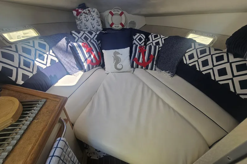 Slide: The Image of 1999 Maxum 2400 SCR cabin with nautical-themed cushions and decor. - 17