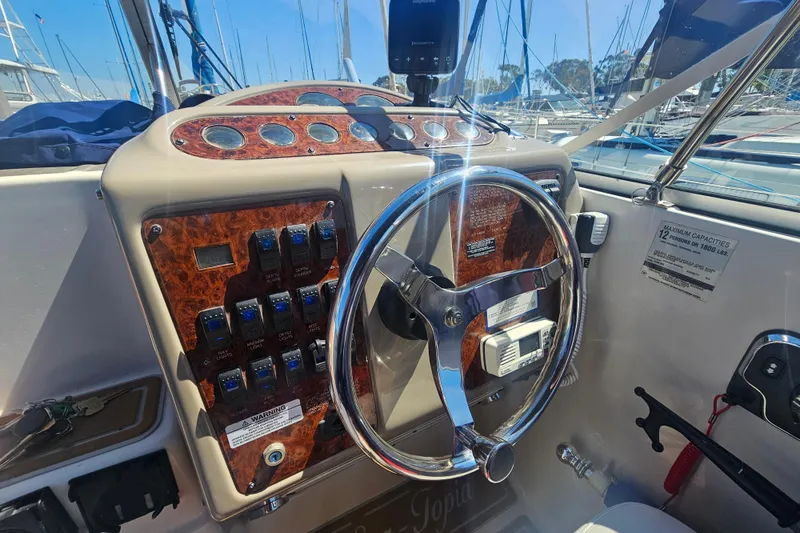 Slide: The Image of Steering wheel and control panel of a 1999 Maxum 2400 SCR boat. - 2