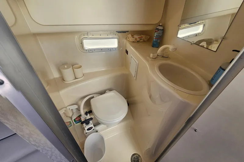Slide: The Image of Compact bathroom in 1999 Maxum 2400 SCR boat with toilet, sink, and mirror. - 22