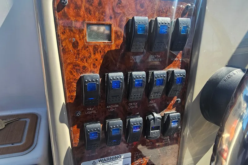 Slide: The Image of Control panel of a 1999 Maxum 2400 SCR boat with various switches and labels. - 4