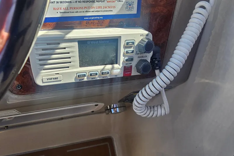Slide: The Image of VHF radio on 1999 Maxum 2400 SCR boat dashboard with coiled microphone. - 6
