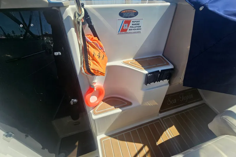 Slide: The Image of 1999 Maxum 2400 SCR boat interior with safety equipment and wooden flooring. - 7