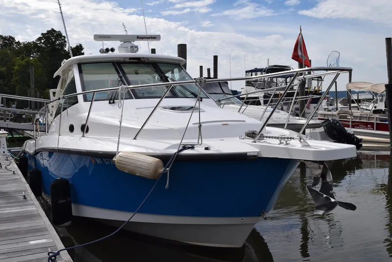 Slide: The Image of 2011 Boston Whaler 345 Conquest boat docked at marina, blue hull, clear sky. - 0
