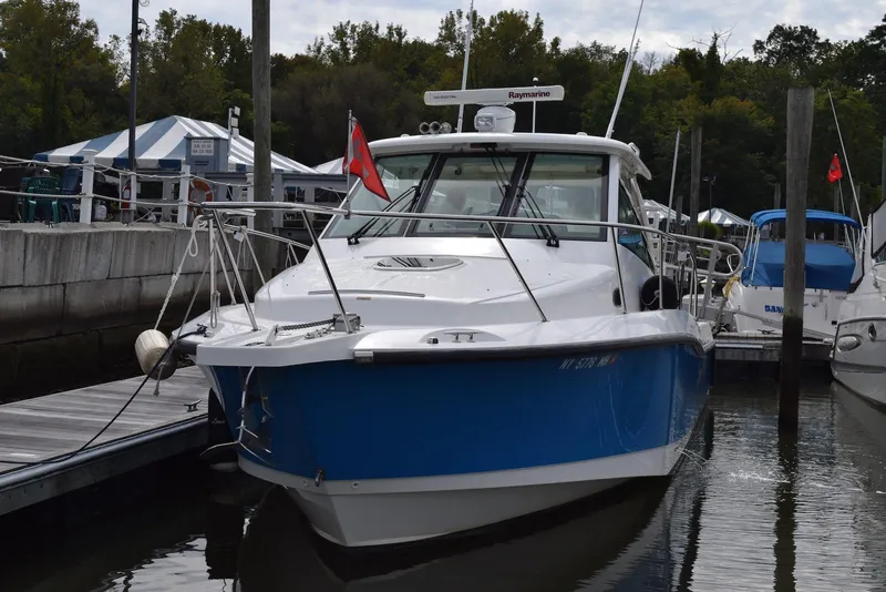 Slide: The Image of 2011 Boston Whaler 345 Conquest docked at marina, blue hull, overcast sky. - 1