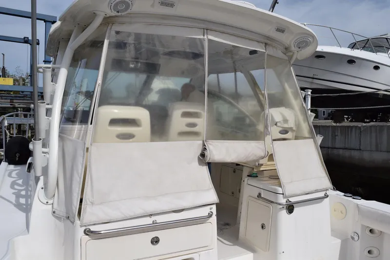 Slide: The Image of 2011 Boston Whaler 345 Conquest boat with enclosed cockpit, docked at marina. - 2