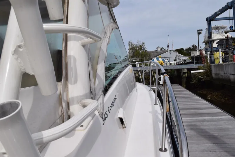 Slide: The Image of 2011 Boston Whaler 345 Conquest docked, showcasing sleek design and sturdy railings. - 3