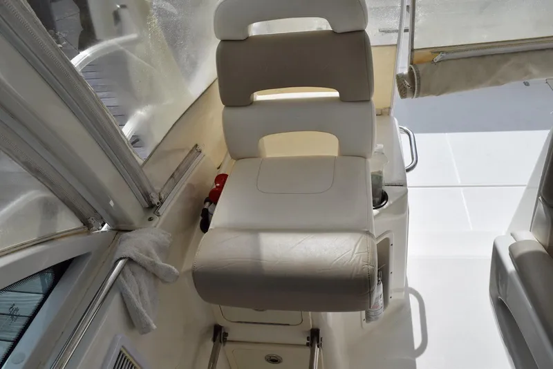 Slide: The Image of 2011 Boston Whaler 345 Conquest helm seat with beige upholstery and surrounding cockpit area. - 9