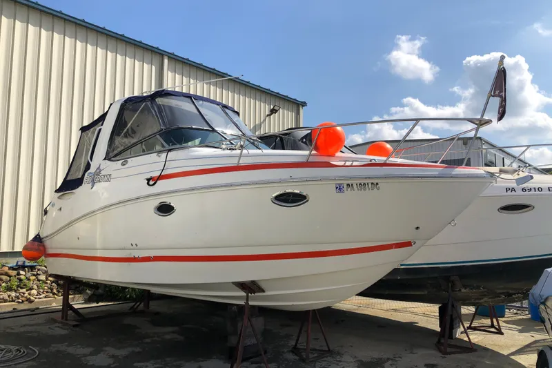 The Image of 2008 Rinker 260 Express Cruiser boat on dry dock with orange fenders. - 1