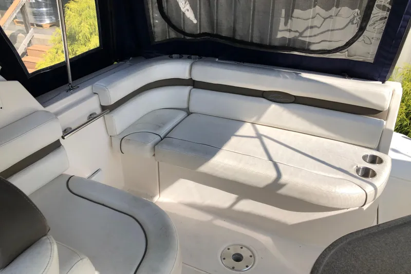 Slide: The Image of 2008 Rinker 260 Express Cruiser interior with white seating and cup holders. - 7