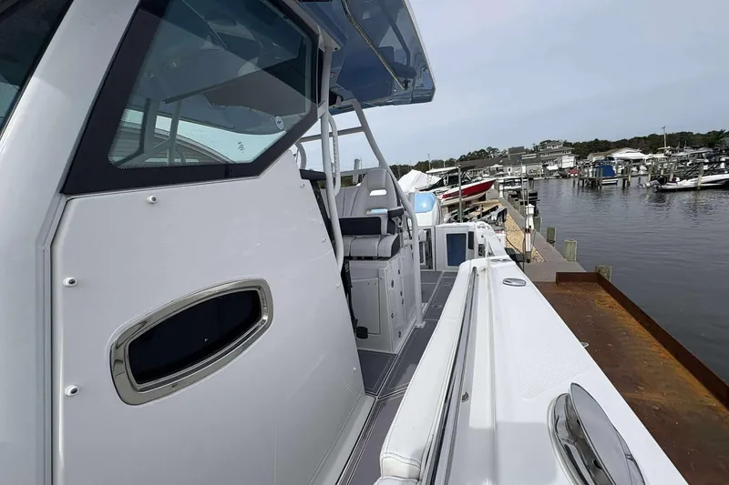 Slide: The Image of 2023 Blackfin 332cc boat docked at a marina, showcasing sleek design and modern features. - 10