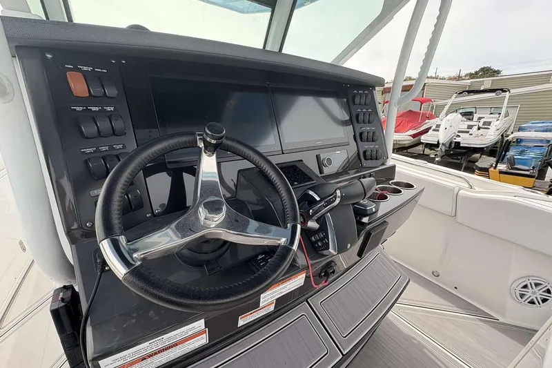Slide: The Image of 2023 Blackfin 332cc boat dashboard with steering wheel and control panel. - 24
