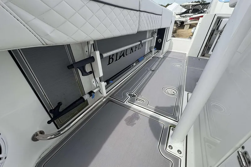 Slide: The Image of 2023 Blackfin 332cc boat interior with rod holders and cushioned seating. - 25
