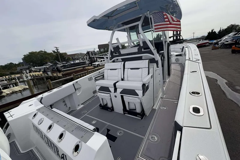 Slide: The Image of 2023 Blackfin 332cc boat with sleek design and American flag at marina. - 4