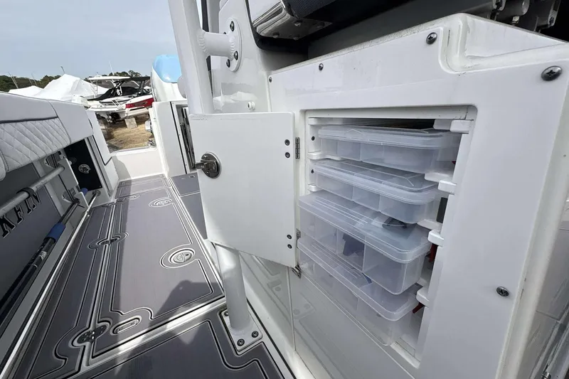 Slide: The Image of 2023 Blackfin 332cc boat storage compartment with organized tackle boxes. - 9