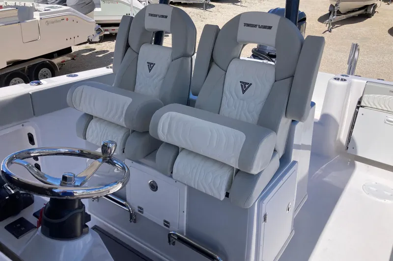 Slide: The Image of 2026 Twin Vee 280 GFX CC boat interior with dual cushioned seats and steering wheel. - 12