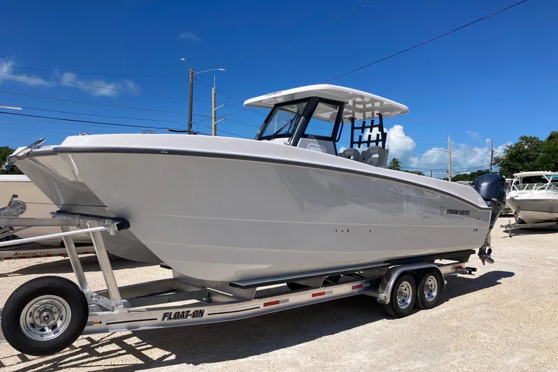 Slide: The Image of 2026 Twin Vee 280 GFX CC boat on trailer under clear blue sky. - 4
