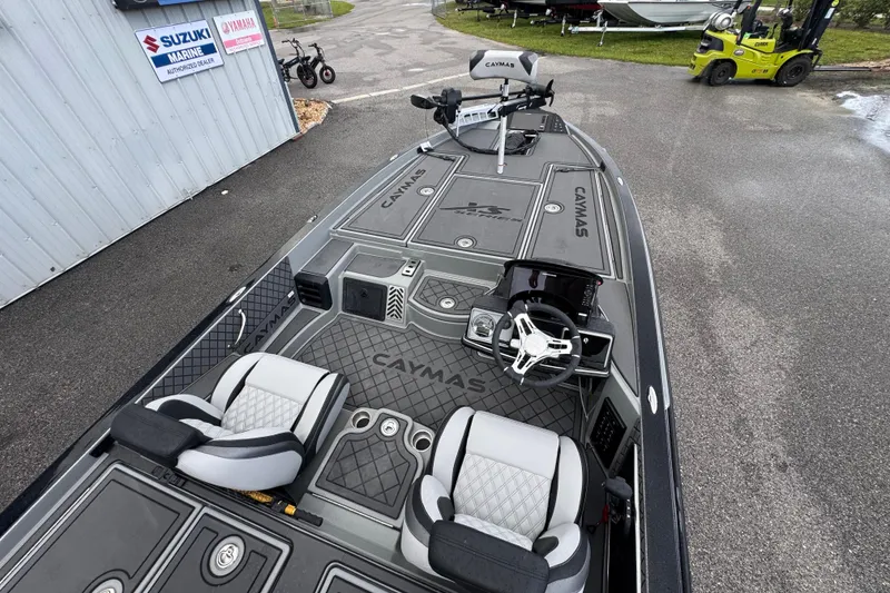 Slide: The Image of 2026 Caymas XS 20 Pro boat interior with steering wheel and seats, parked near marine dealership. - 19