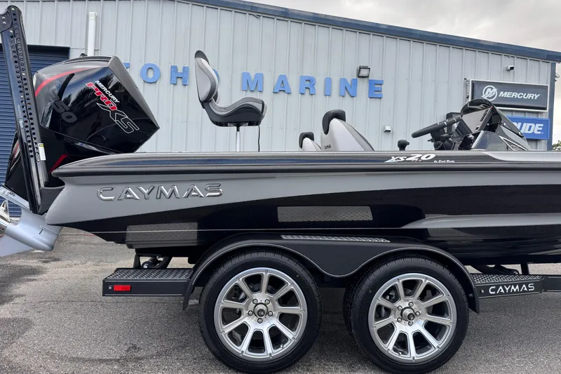Slide: The Image of 2026 Caymas XS 20 Pro boat with dual axle trailer, parked outside marine dealership. - 3