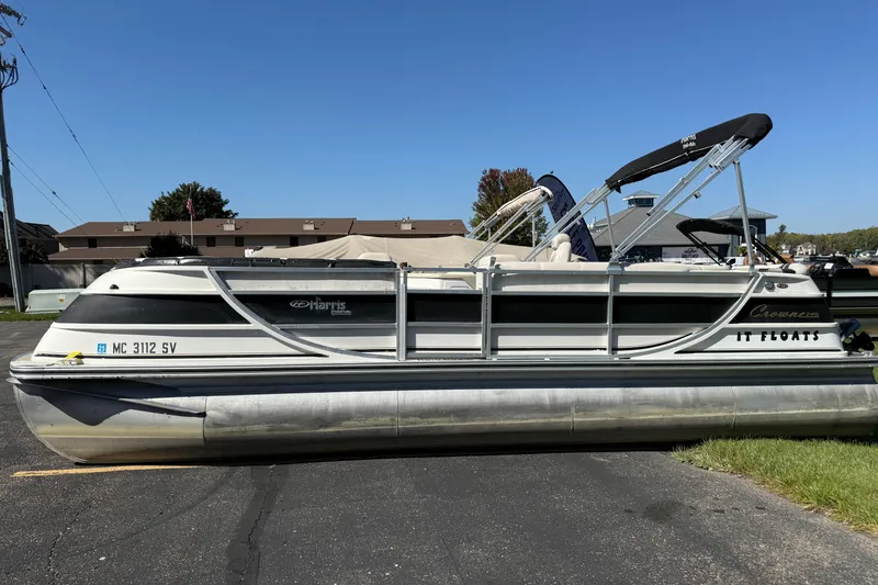 Slide: The Image of 2005 Harris FloteBote 270 Crowne pontoon boat parked on pavement under clear blue sky. - 0