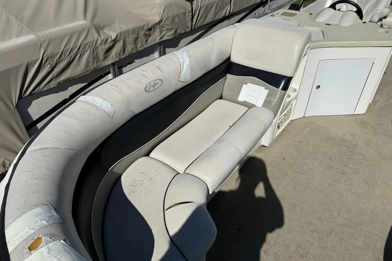 Slide: The Image of 2005 Harris FloteBote 270 Crowne boat interior with worn seating and storage compartment. - 10