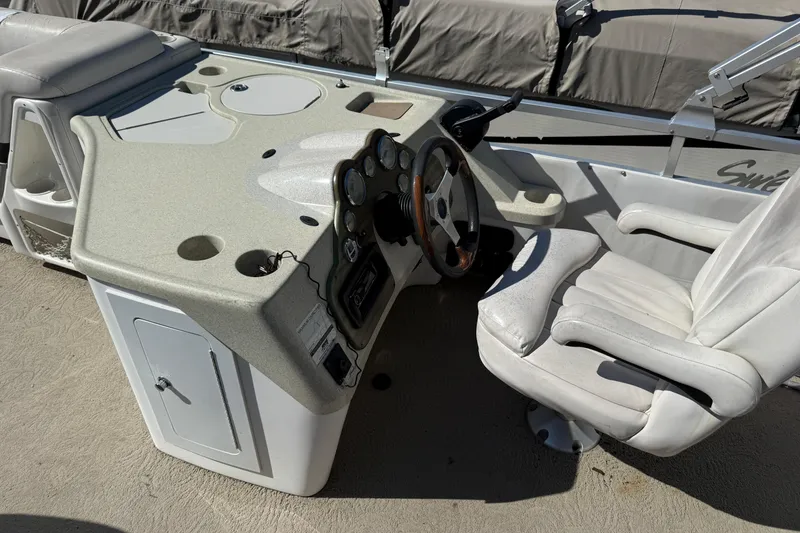 Slide: The Image of 2005 Harris FloteBote 270 Crowne boat helm with steering wheel and white captain's chair. - 15