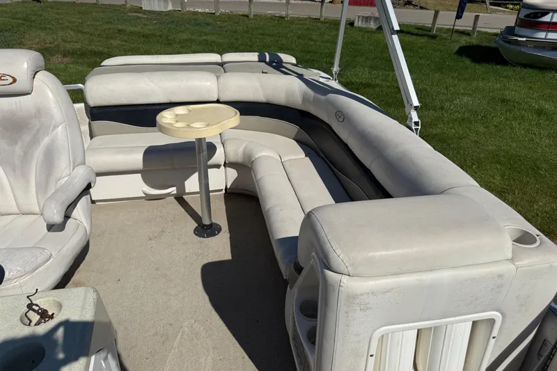 Slide: The Image of 2005 Harris FloteBote 270 Crowne pontoon boat interior with white seating and small table. - 19