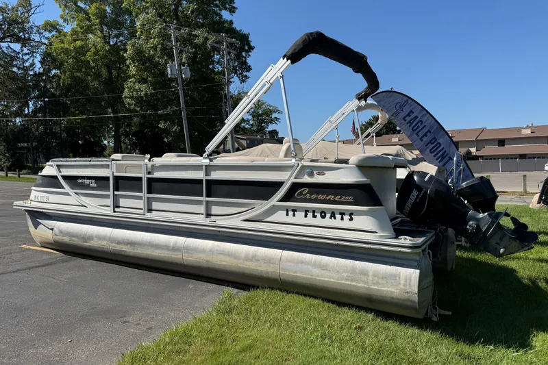 Slide: The Image of 2005 Harris FloteBote 270 Crowne pontoon boat displayed outdoors on grass. - 4