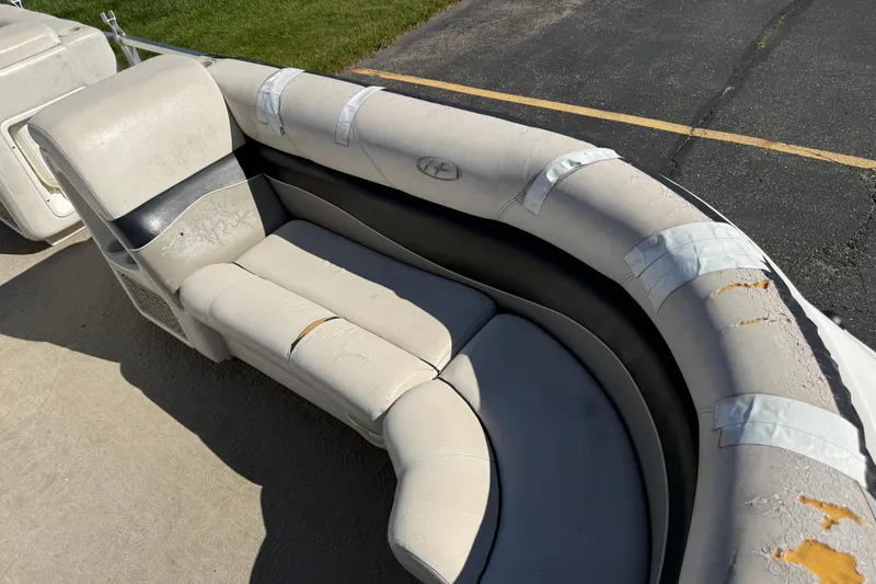 Slide: The Image of Worn seating on 2005 Harris FloteBote 270 Crowne pontoon boat, showing visible damage and tape repairs. - 9
