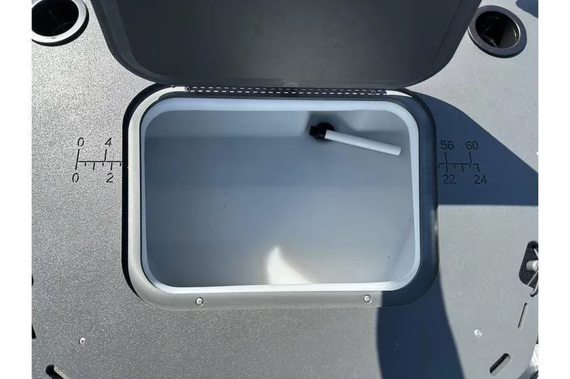 Slide: The Image of Open storage compartment on 2025 Bennington 20 SF Family boat with measurement markings. - 11