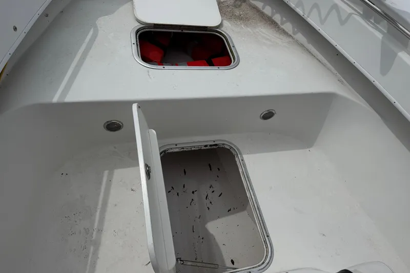 Slide: The Image of 2018 Cape Horn 27 boat storage compartments with open hatches and visible life jackets. - 11